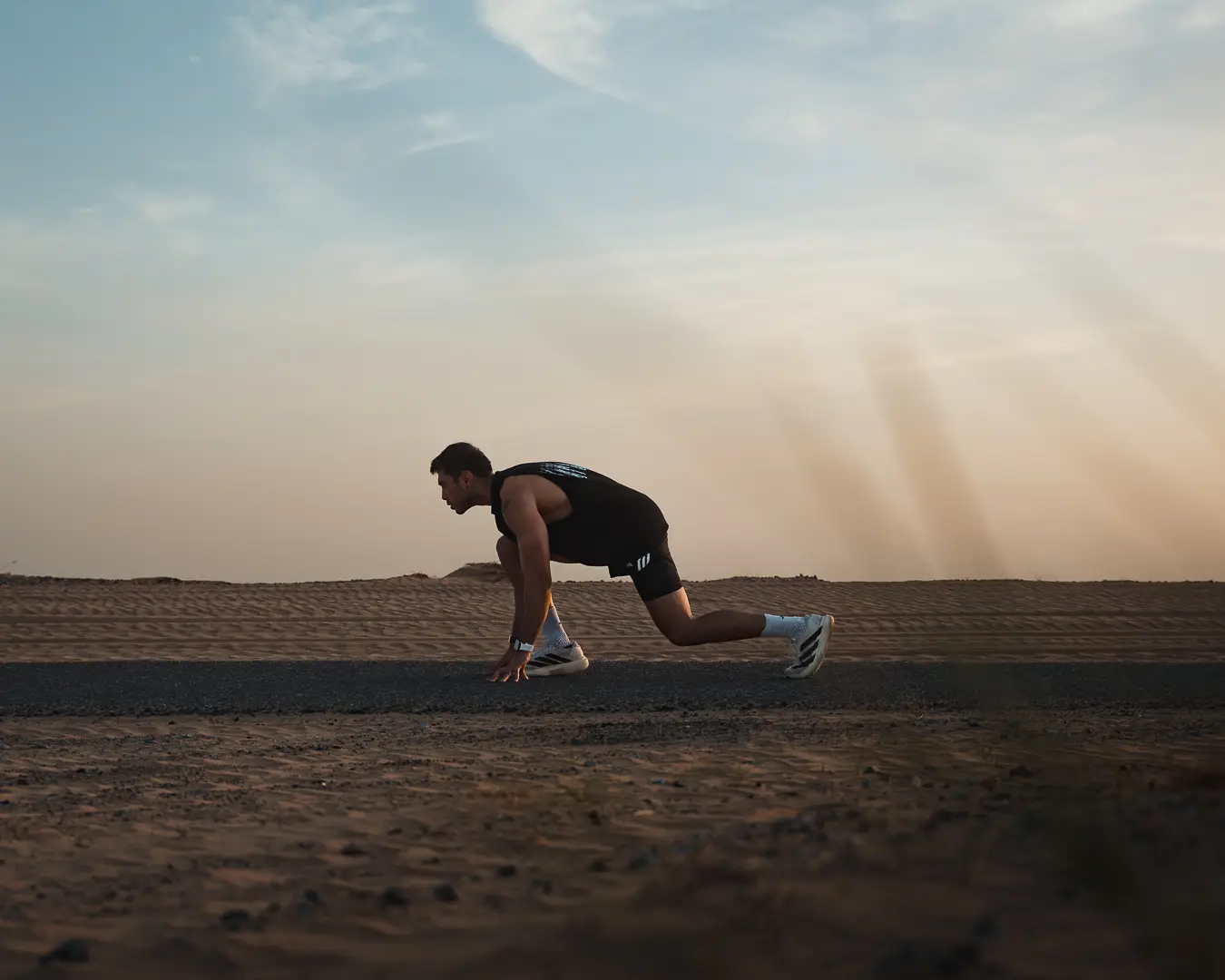 Athlete crouched in a sprint start on a desert track