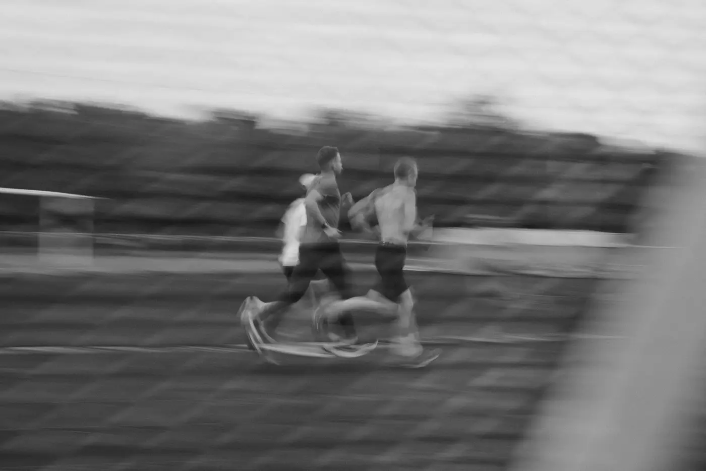 Three runners racing on a track, motion blur